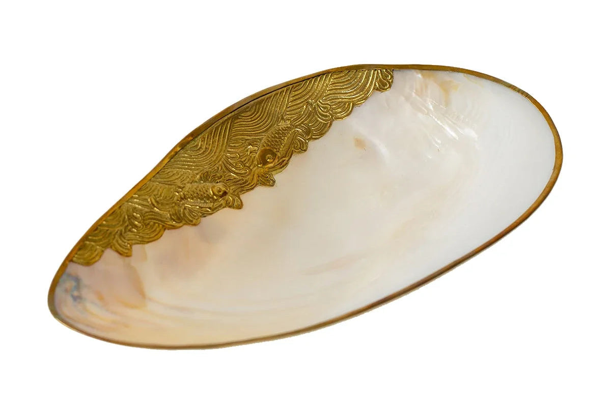 Decorative plate with gold edge and shell design on a white background