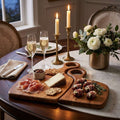Dining table set with appetizers, glasses of champagne, and a floral arrangement.